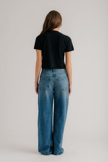 a woman in black shirt and blue jeans